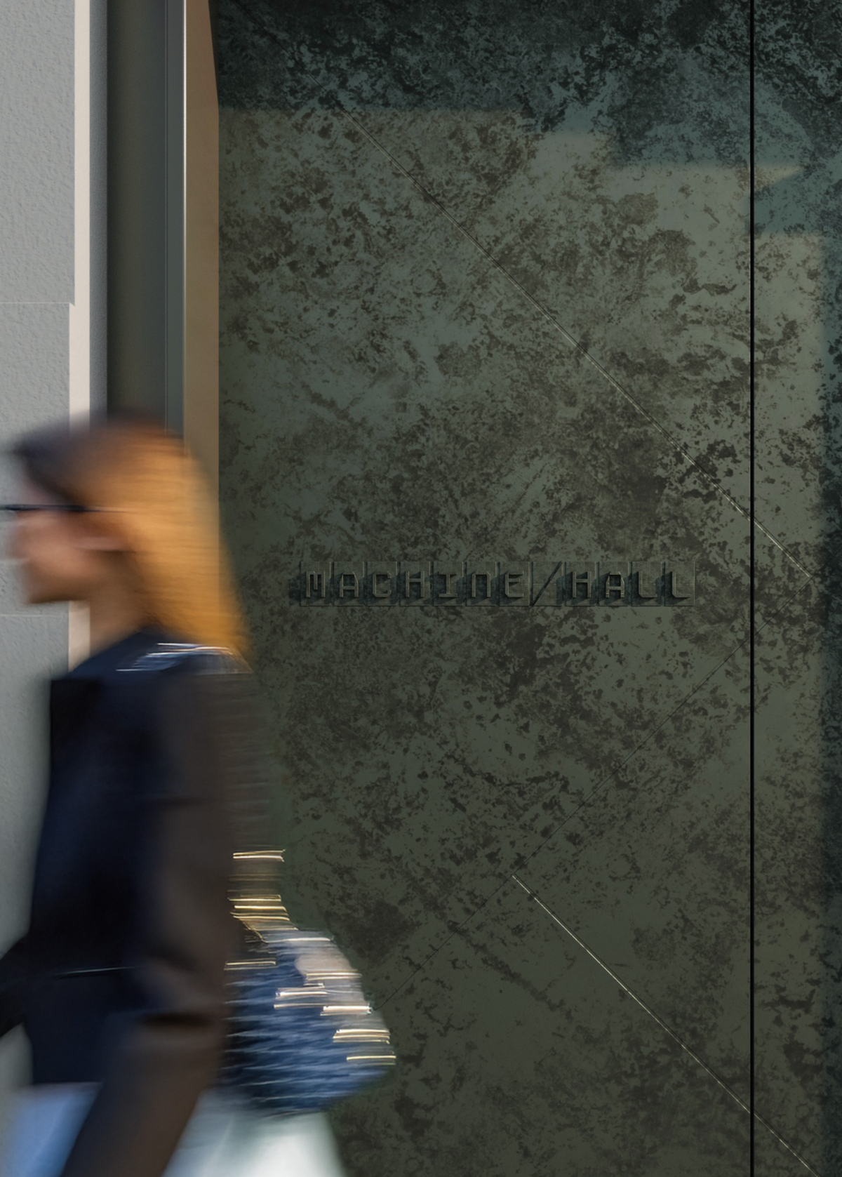 Woman walking past Machine Hall outside