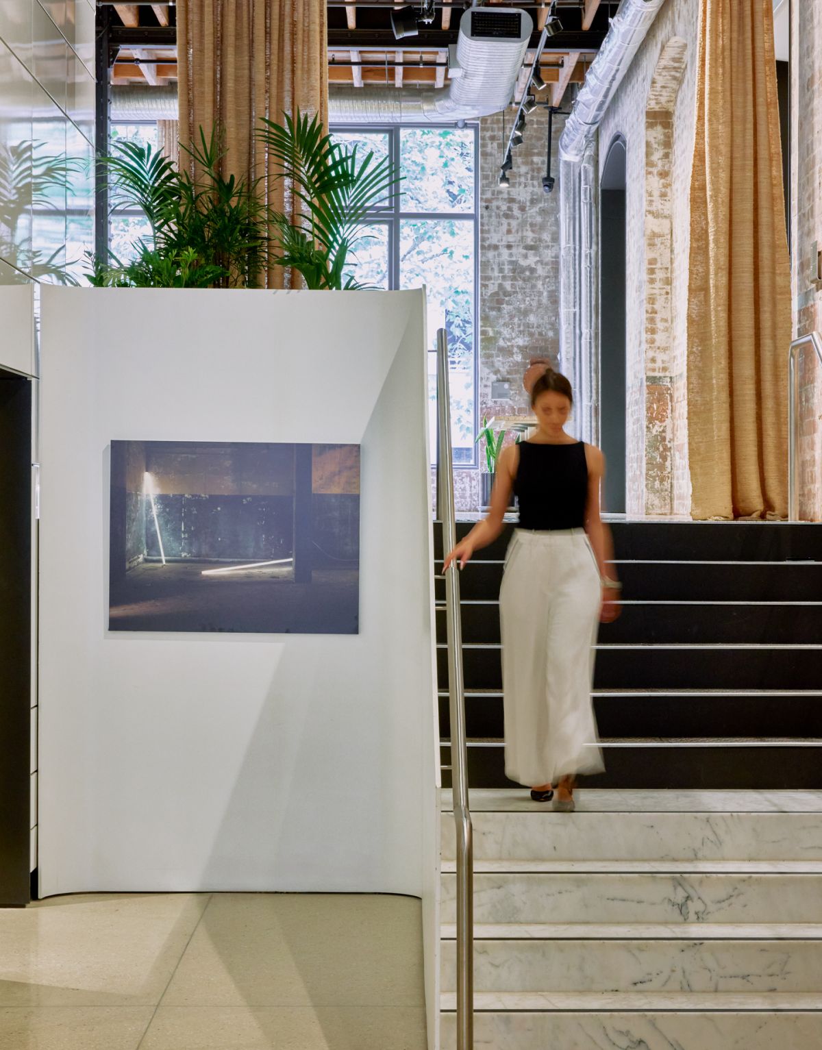 Woman walks down stairs inside Machine Hall