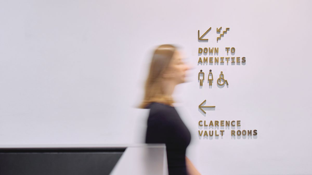 Woman walking past indoor Machine Hall signage